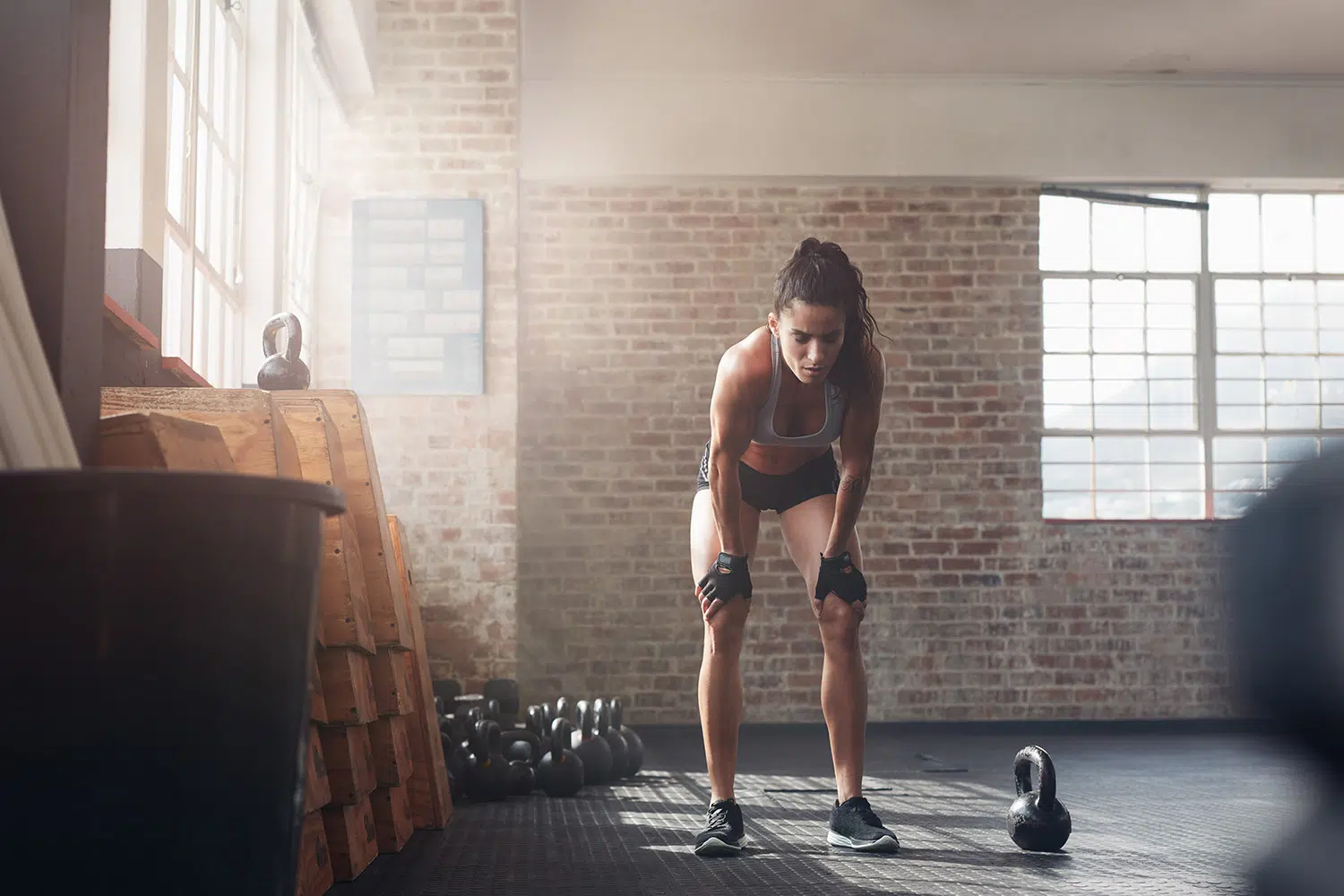 Une femme sportive s'entraîne avec des kettlebell au fitness